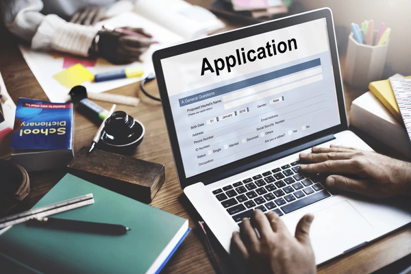 Student applying for online psychology degree admission on laptop with checklist